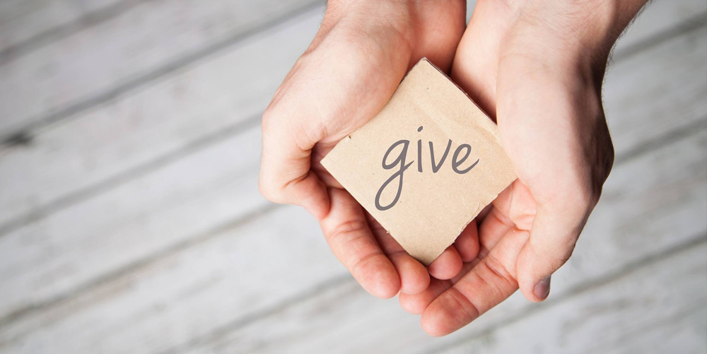 Give sign being held between a man's hands